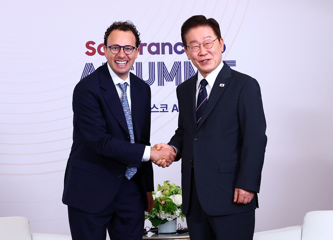President Lee Jae Myung (rigt) exchanges greetings with Dario Amodei, CEO of U.S. artificial intelligence company Anthropic, before their meeting in San Francisco on Saturay. (Yonhap)