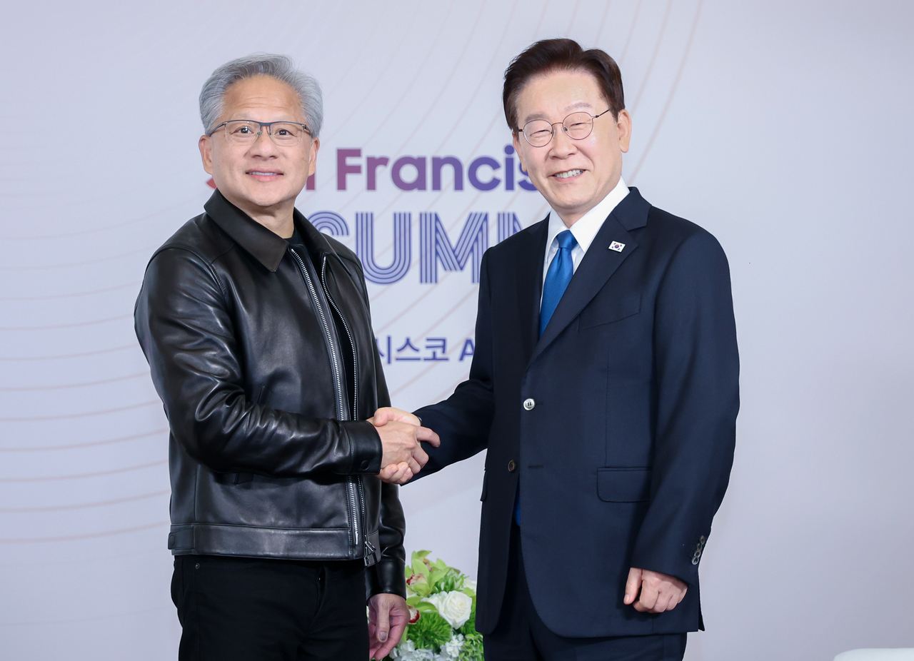 President Lee Jae Myung (right) and Jensen Huang, the chief of US tech giant Nvidia Corp., shake hands during their meeting in San Francisco on Friday. (Yonhap)