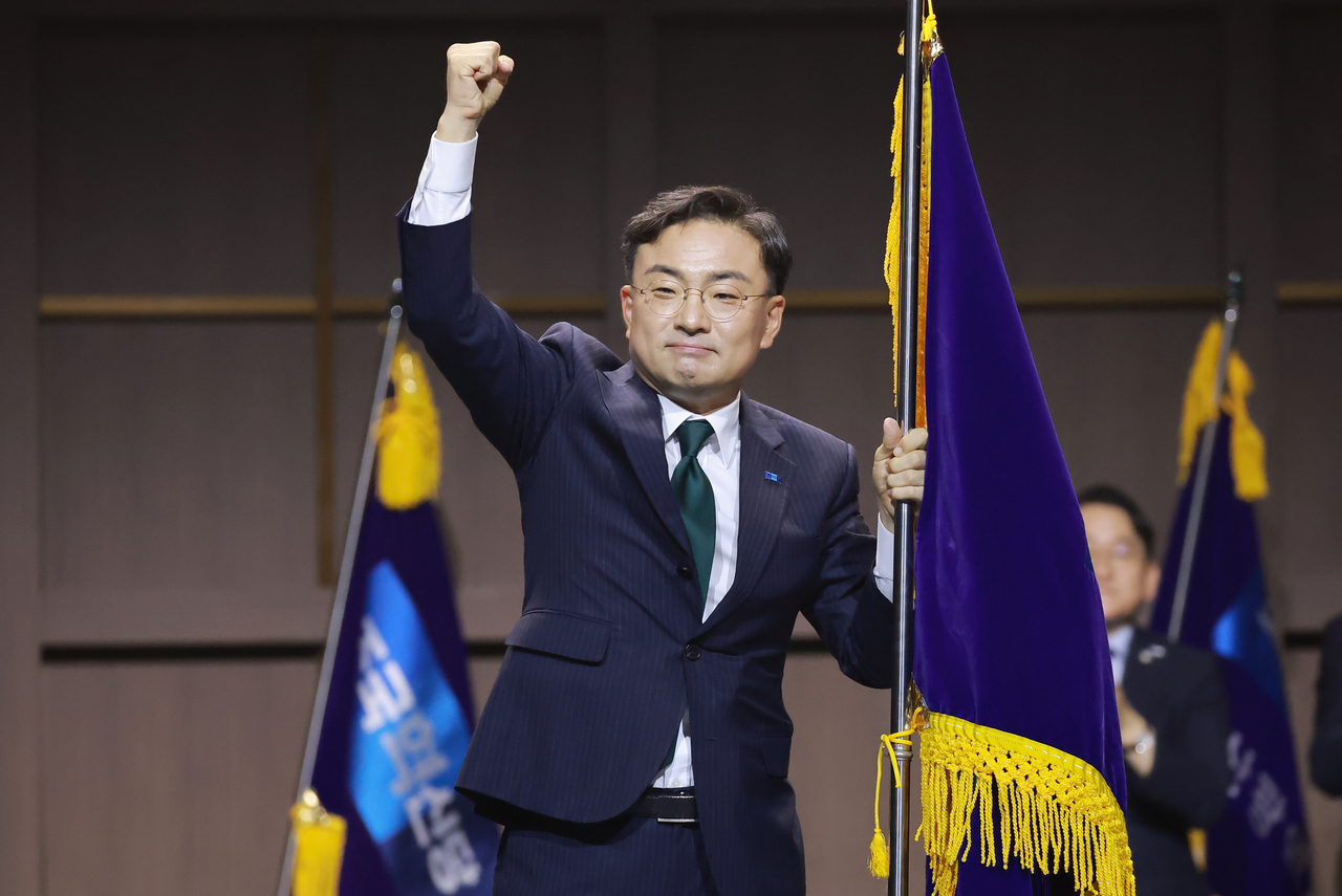 조국혁신당 신임 대표로 선출된 신장식 의원이 25일 경기도 수원컨벤션센터에서 열린 전국당원대회에서 당기를 들고 주먹을 들어올려 보이고 있다. [연합]