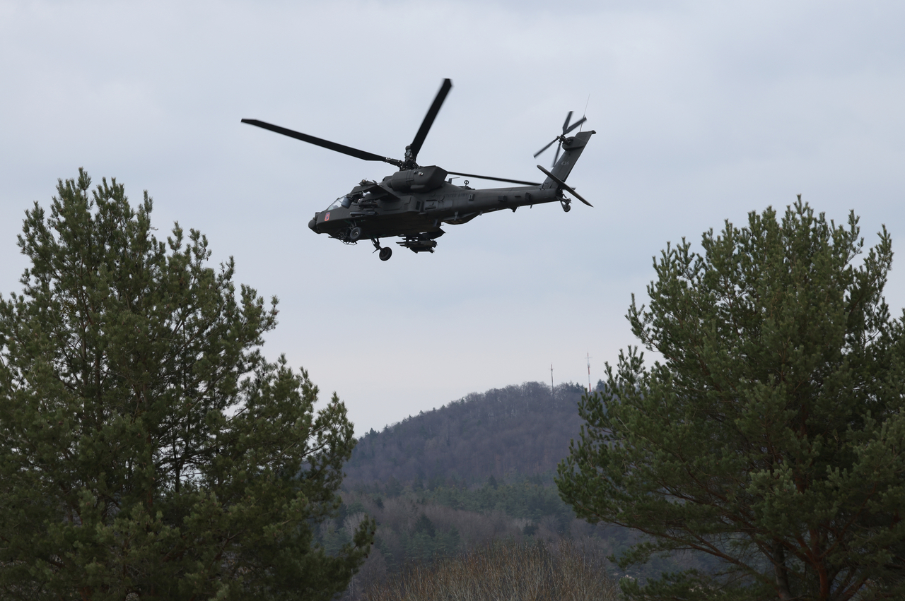 A US Army AH-64 Apache attack helicopter flies overhead. [Getty Images]