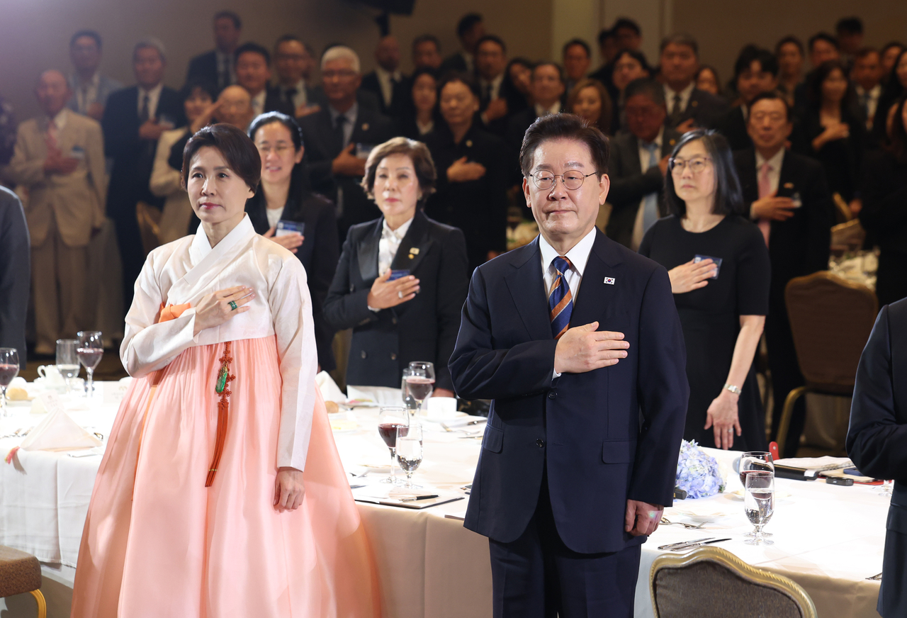 이재명 대통령과 김혜경 여사가 25일(현지시간) 샌프란시스코 한 호텔에서 열린 동포 오찬간담회에서 국기에 경례를 하고 있다. [연합]