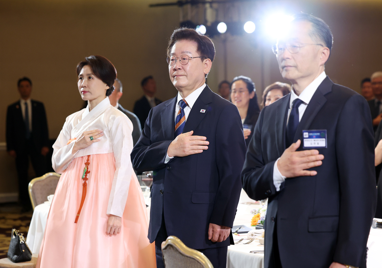 President Lee Jae Myung and first lady Kim Hye-kyung salute the national flag at a luncheon with Korean diaspora members at a hotel in San Francisco on Saturday (local time). [Yonhap]