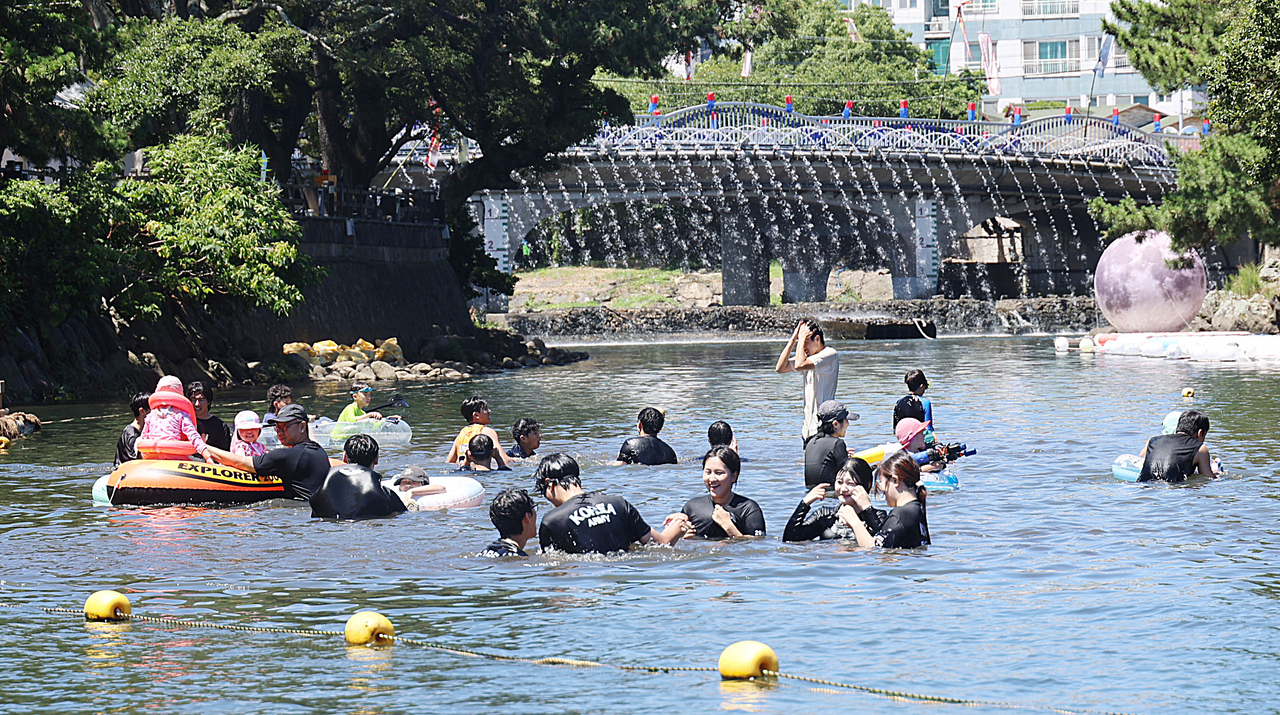 Residents and tourists cool off in the water at the 11th Woldaecheon Festival in Oeodo-dong, Jeju, on Sunday, as a prolonged heatwave and tropical nights push the cumulative number of heat illness cases in the region past 40. [Yonhap]