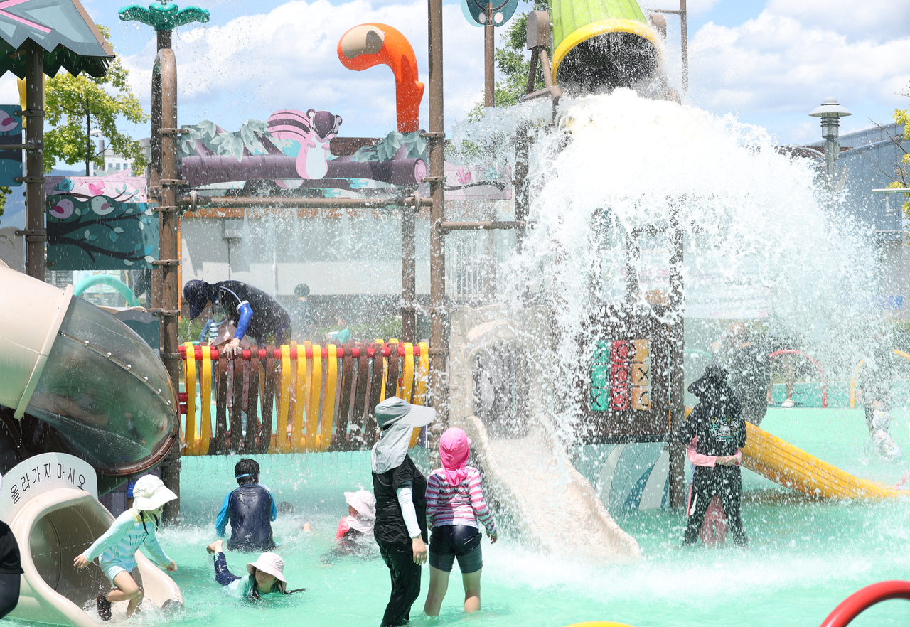 Residents cool off at a water play area in Nammae Park in Gyeongsan, North Gyeongsang Province, on Sunday, as extreme heat alerts were issued across seven cities and counties in South Gyeongsang Province, where Yangsan recorded a daytime high of 39.3 C. [Yonhap]