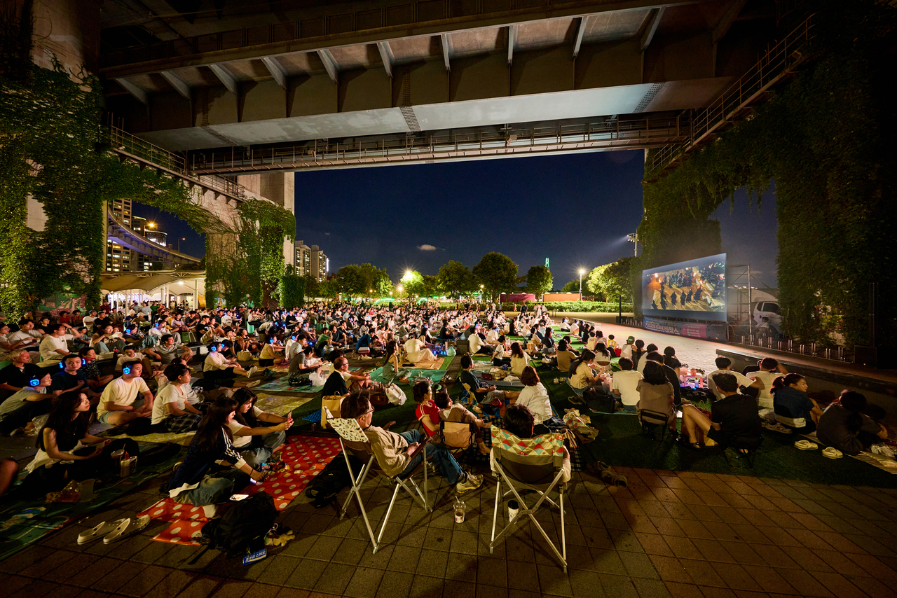 Visitors watch an outdoor movie screening beneath a bridge over the Han River. (Seoul Metropolitan Government)