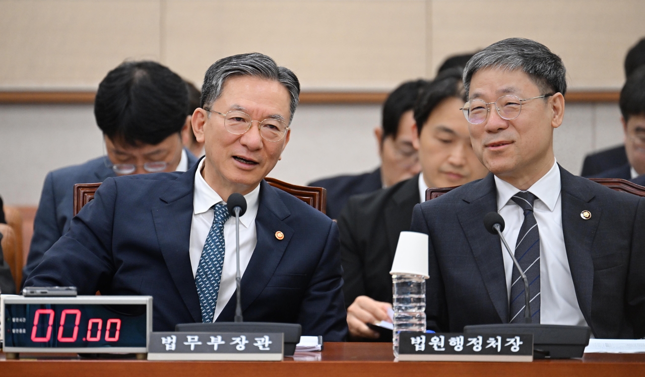 정성호 법무부 장관이 27일 오전 서울 여의도 국회에서 열린 법제사법위원회 전체회의에 참석해 노경필 법원행정처장과 대화하고 있다. 이상섭 기자