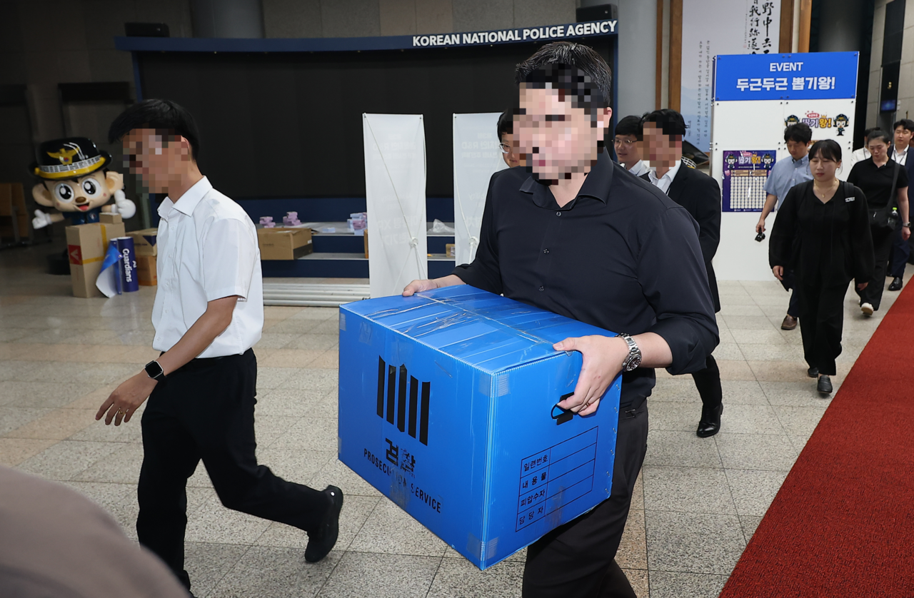 지난 21일 서울 서대문구 경찰청에서 검찰 관계자들이 압수물이 담긴 상자를 들고 이동하고 있다. 검찰은 경찰이 장윤기 사건을 은폐·부실 수사했다는 의혹을 규명하기 위해 이날  경찰청 국가수사본부를 압수수색했다. [연합]
