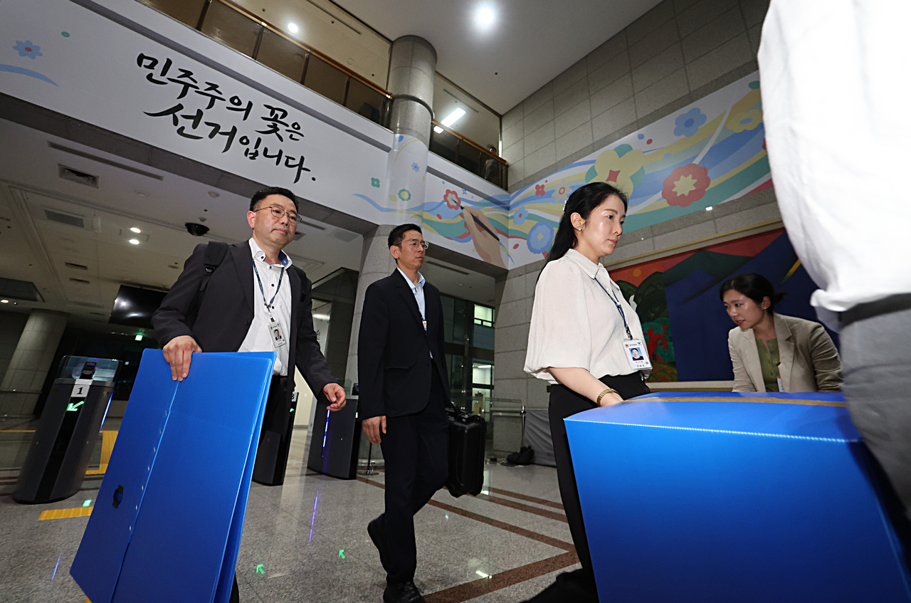 Investigators leave the National Election Commission in Gwacheon, just south of Seoul, on Thursday, after executing a search and seizure warrant against the election watchdog. (Pool photo via Yonhap)