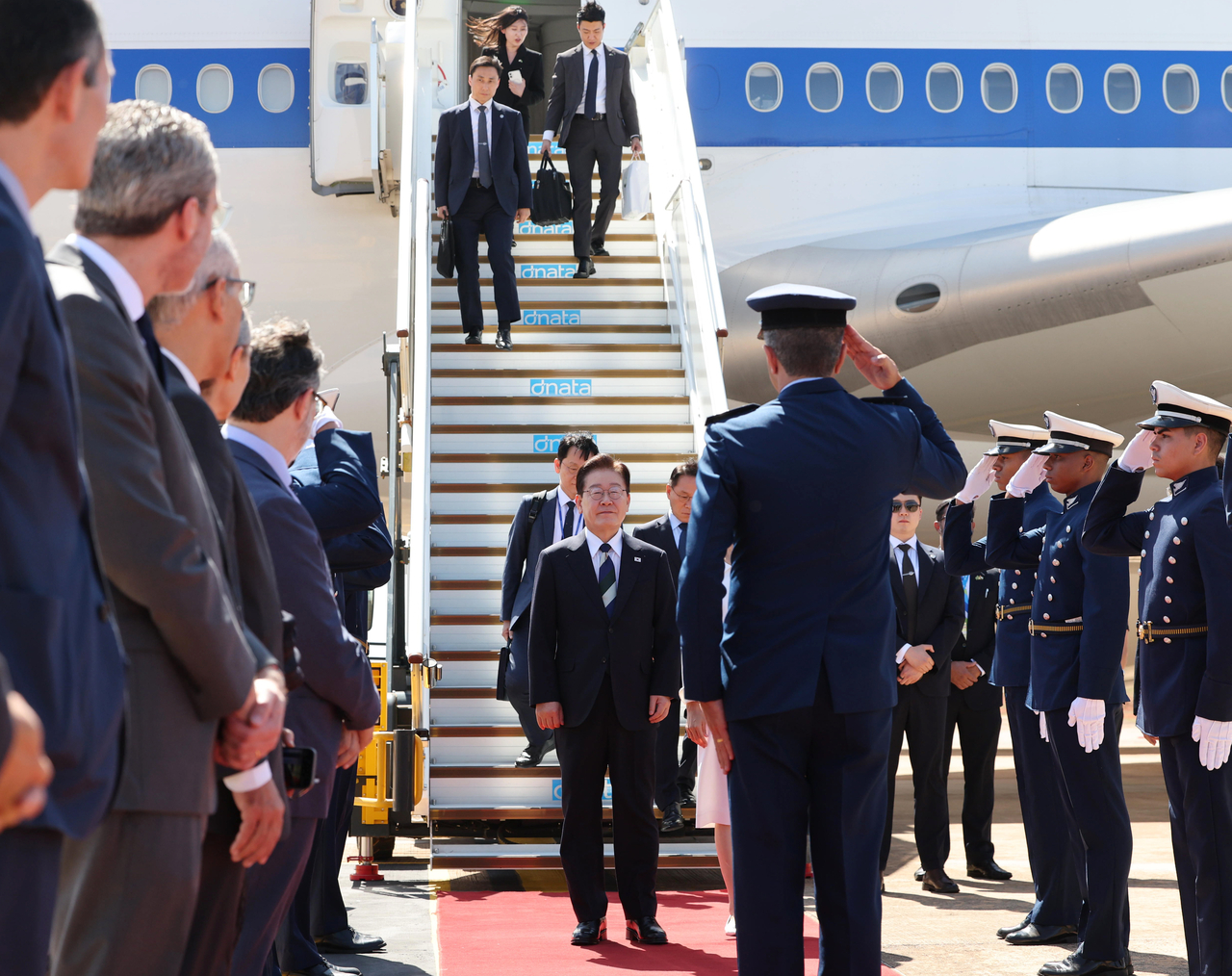 President Lee Jae Myung and first lady Kim Hea Kyung receive a salute after disembarking from Air Force One at an air base in Brasilia on Sunday during their state visit to Brazil. (Yonhap)