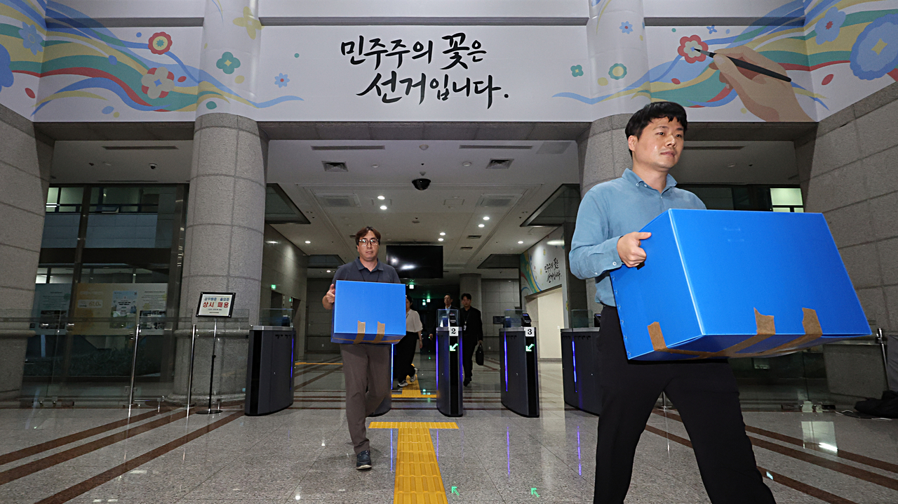 A joint team of police and prosecutors leave the National Election Commission in Seoul on Thursday, after conducting a search and seizure of the NEC connected to the ballot shortage during the June 3 local elections. (Yonhap)
