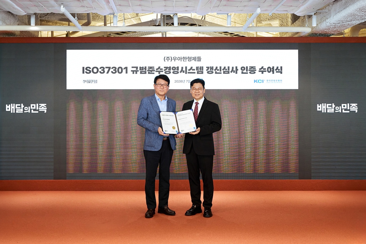 Lee Won-jae (right), lead of governance, risk & compliance at Woowa Brothers receives an iSO 37301 certificate from Lee Yong-ki, head of the Korea Compliance Initiative. (Woowa Brothers)