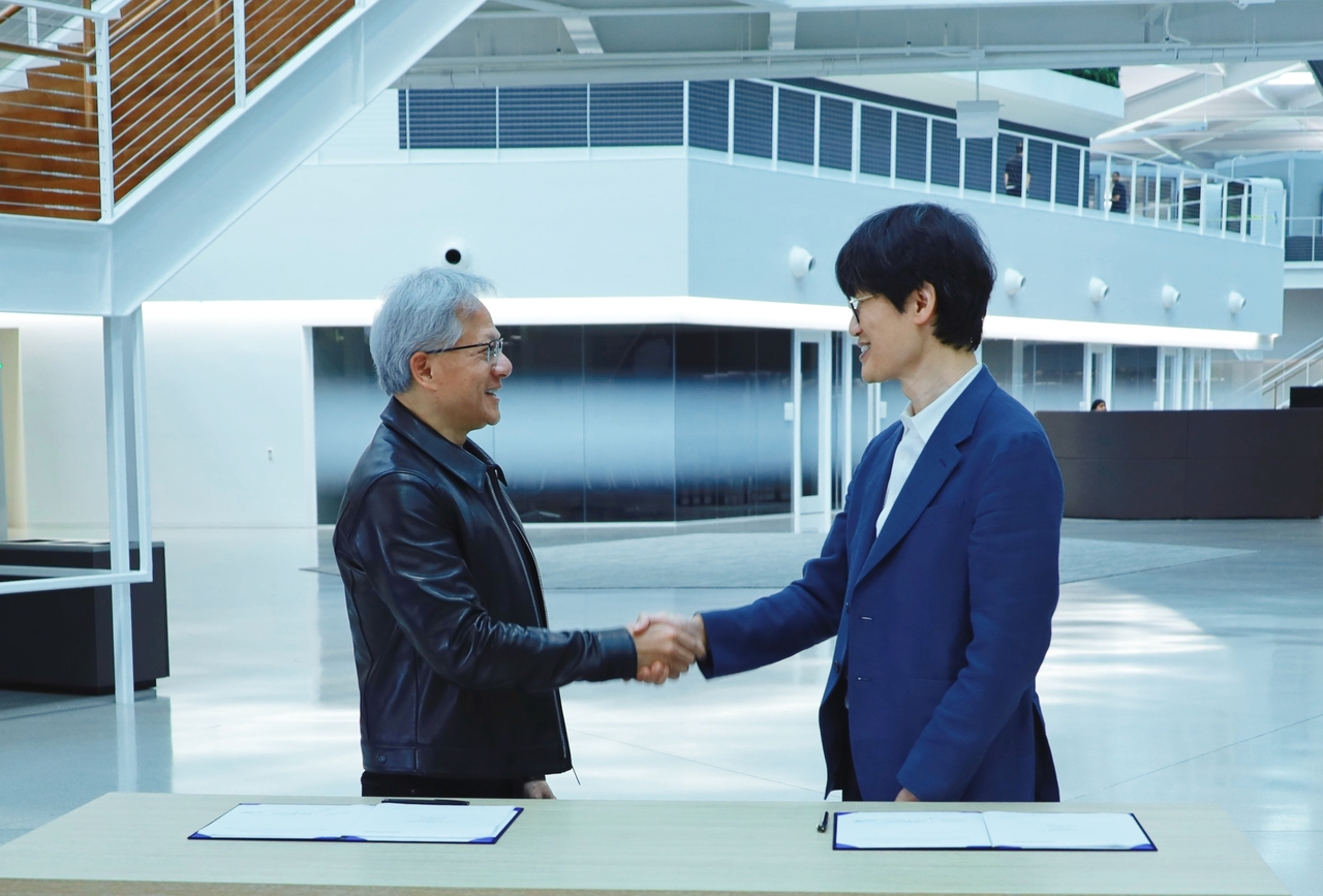 Nvidia CEO Jensen Huang (left) and Naver Chairman Lee Hae-jin shake hands after signing an investment agreement at Nvidia's headquarters in Santa Clara, California, on July 24. (Naver)