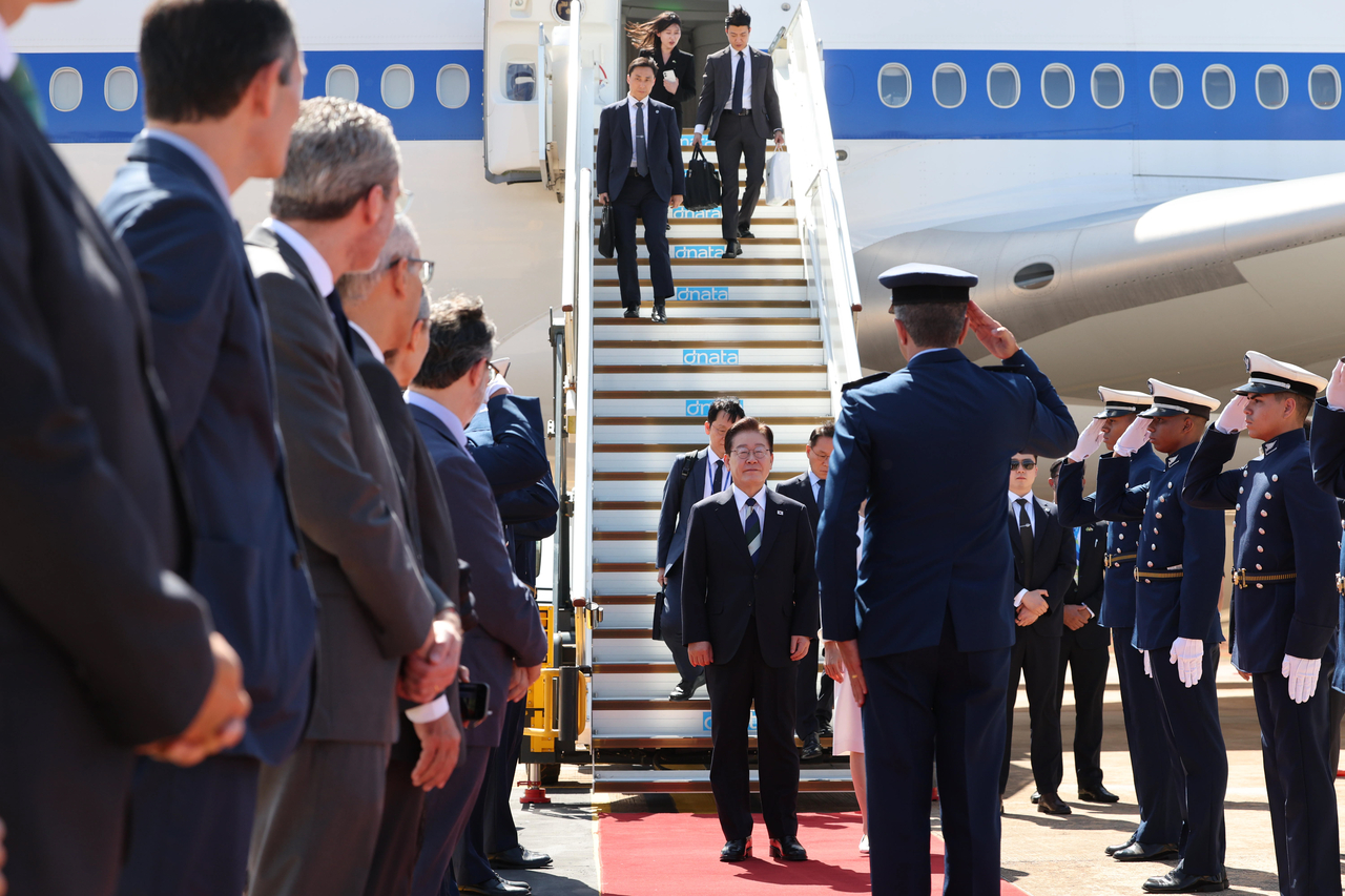 South Korean President Lee Jae Myung (center) arrives at the Brazilian Air Force's base in Brasilia, Brazil, on Sunday for a summit with Brazilian President Luiz Inacio Lula da Silva. (Newsis)