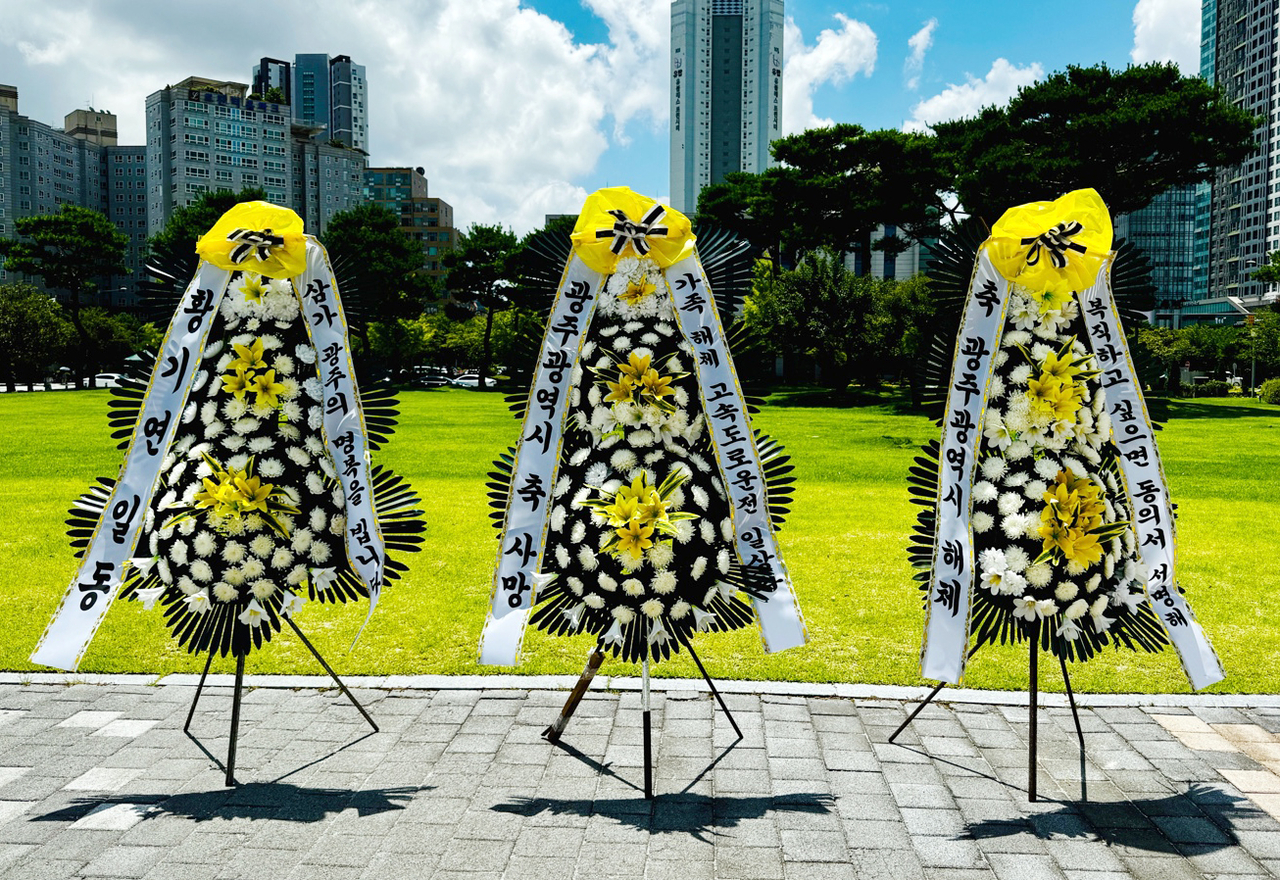 24일 낮 전남광주 서구 전남광주통합특별시 광주청사 앞에 기획·예산·조직 등의 기관 유지 기능을 광주·무안·동부청사로 분산하는 조직개편에 반발하는 내용의 근조화환이 놓여있다. <연합뉴스>