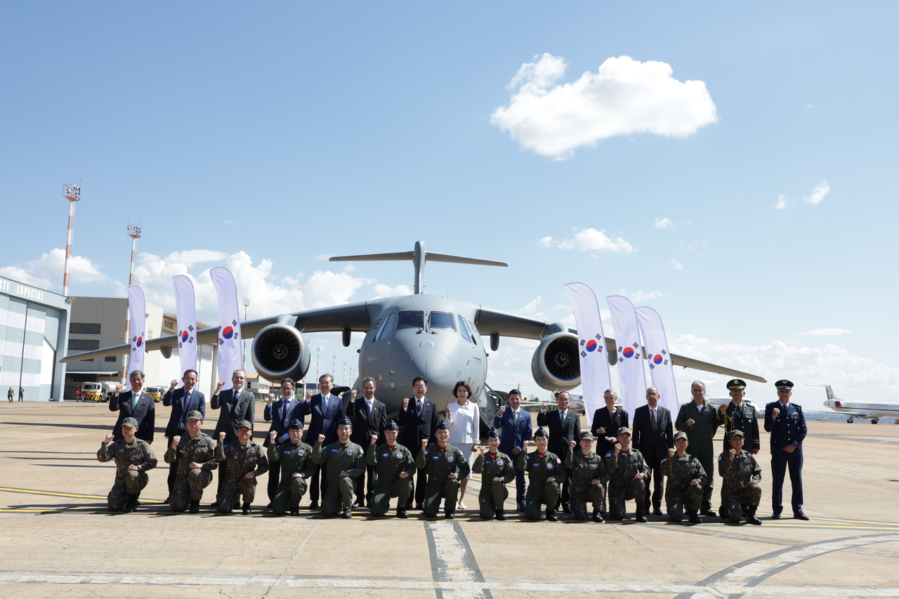 President Lee Jae Myung, on a state visit to Brazil, poses for a photo with South Korean Air Force pilots, maintenance personnel and other crew members undergoing training after inspecting the South Korean Air Force's C-390 military transport aircraft, purchased from Brazil's Embraer, at Brasília Air Base on July 26. (Yonhap)