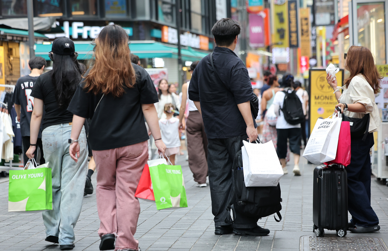 Shoppers walk down a street in Myeong-dong, central Seoul, on Saturday. (Yonhap)