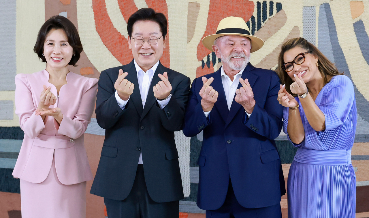 South Korean President Lee Jae Myung (second from left), first lady Kim Hea Kyung (left), Brazilian President Luiz Inacio Lula da Silva (second from right) and first lady Rosangela Lula da Silva make finger-heart gestures during a cultural performance and welcome reception at the Itamaraty Palace in Brasilia, Brazil, Monday. (Yonhap)