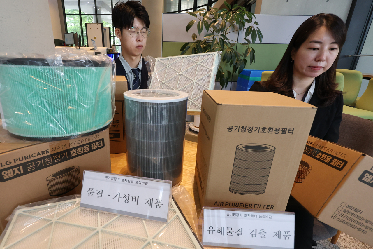 한국소비자원 관계자들이 공기청정기 호환필터 제품을 살펴보고 있다. [연합]