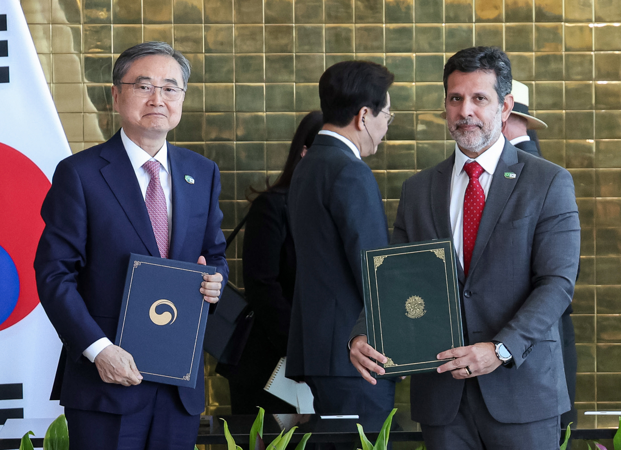 South Korean Foreign Minister Cho Hyun (left) and Brazilian Education Minister Leonardo Barchini pose for a photo on Monday after signing a memorandum of cooperation in education at the Brazilian presidential residence. (Yonhap)