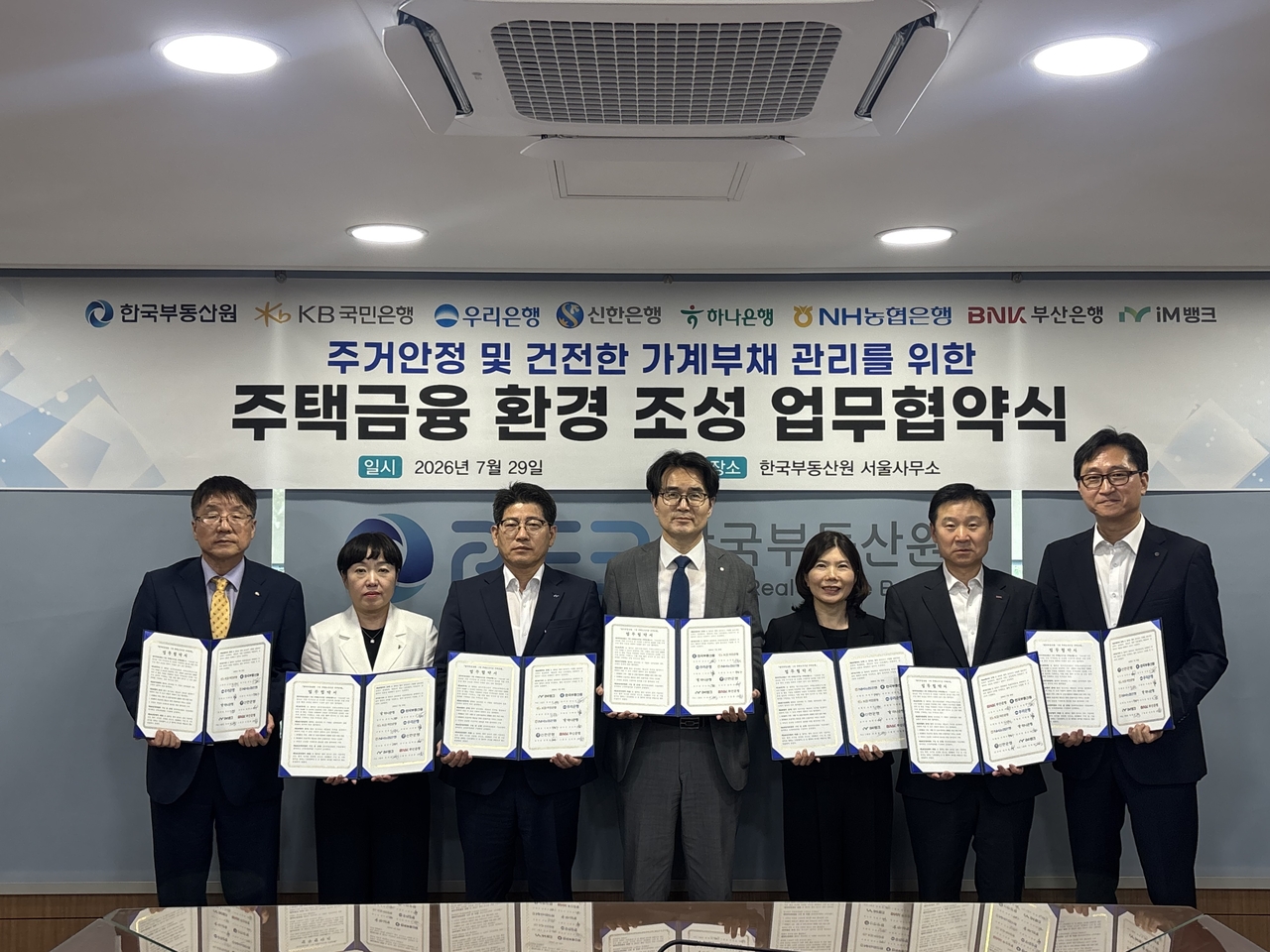 29일 ‘주거안정 및 건전한 가계부채 관리를 위한 주택금융 환경 조성 업무협약’서 김경진(왼쪽부터) 국민은행 부행장, 강은숙 하나은행 본부장, 류희장 아이엠뱅크 여신 그룹장, 김남성 한국부동산원 주택공급지원본부장, 강정미 농협은행 부서장(박현주 농협은행 부행장 대참), 신동훈 부산은행 그룹장, 권혁상 신한은행 본부장이 기념촬영을 하고 있다.[한국부동산원 제공]