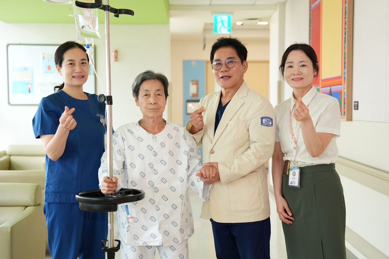 Professor Jang Gi-yuk (right, next to patient) of Seoul St. Mary's Hospital and his medical team pose for a photo with an 89-year-old patient treated with a next-generation TAVI re-intervention after degenerative changes in a previously implanted TAVI valve led to severe aortic stenosis. [Seoul St. Mary's Hospital]