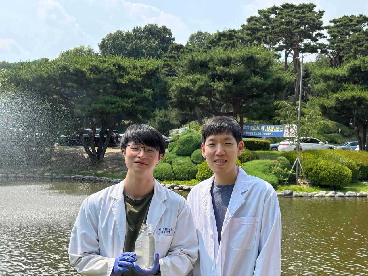 명재욱(오른쪽) KAIST 교수와 김영주 박사과정이 캠퍼스 내 오리연못에서 채수한 담수 시료를 들어 보이고 있다.[KAIST 제공]