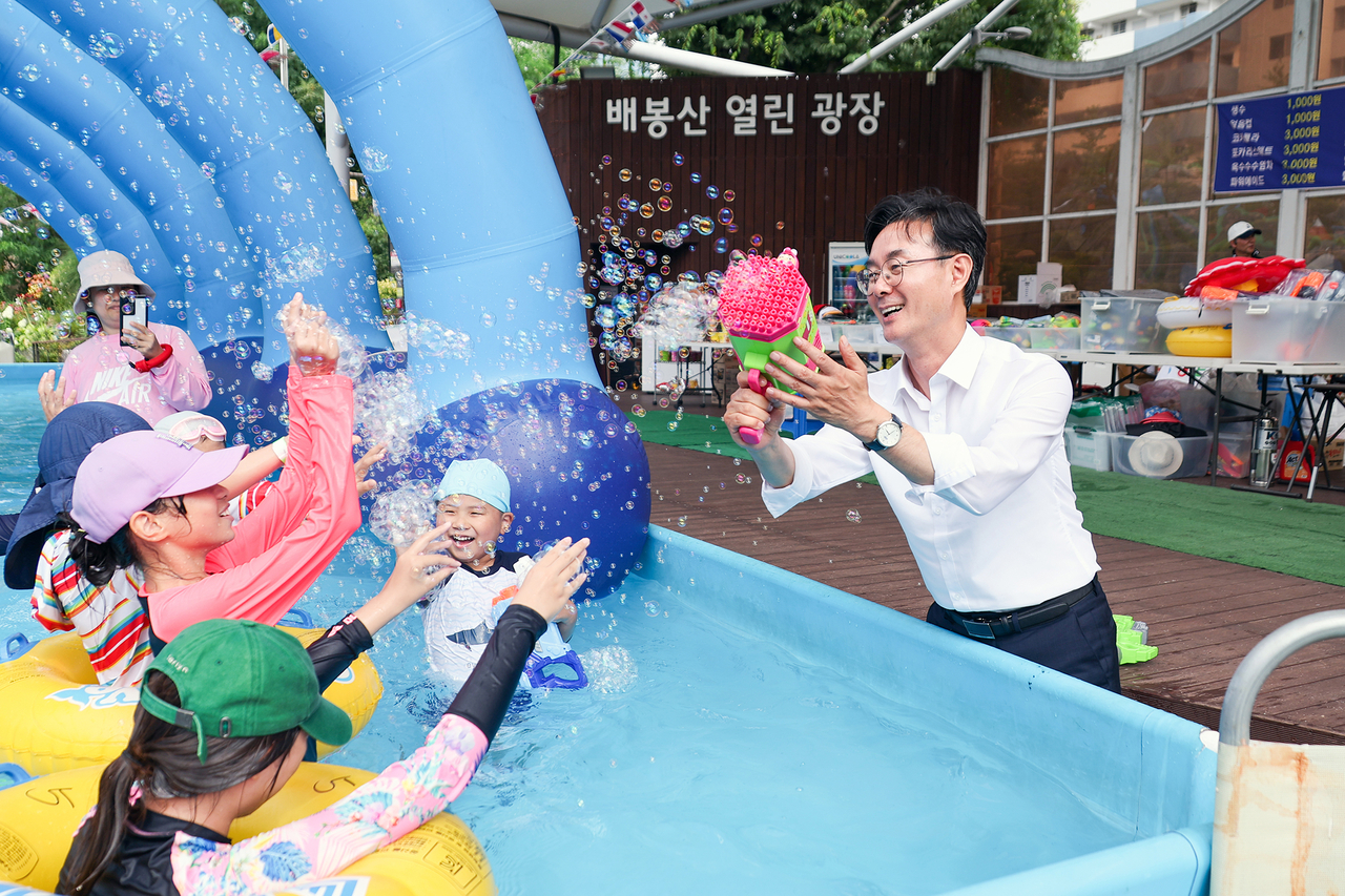 최동민 동대문구청장이 배봉산 물놀이장을 찾아 어린이들과 공놀이를 하고 있다.