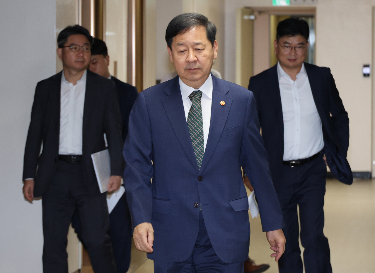 Finance Minister Koo Yun-cheol (center) arrives at the Government Complex Seoul in Jongno-gu, Seoul, on Wednesday for an emergency market monitoring meeting. (Yonhap)
