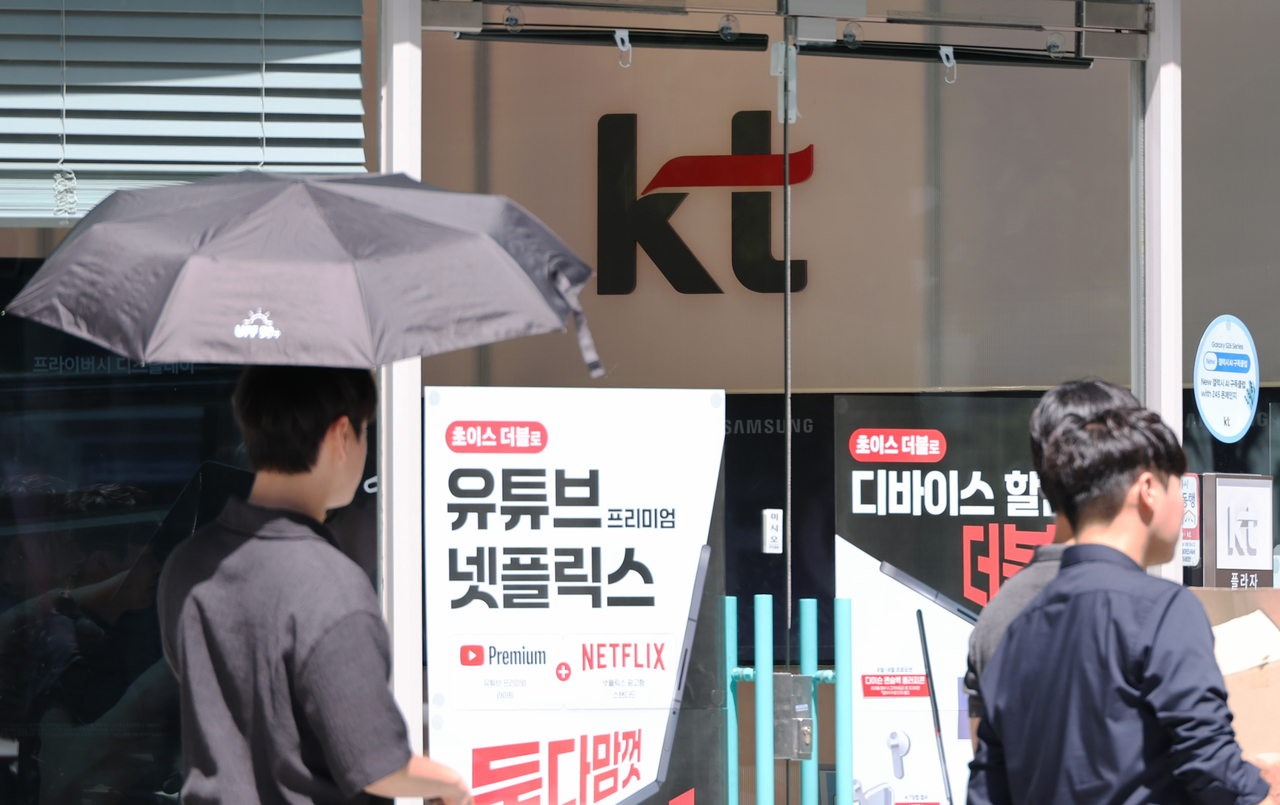 People walk by a KT store in Seoul on Wednesday. (Yonhap)