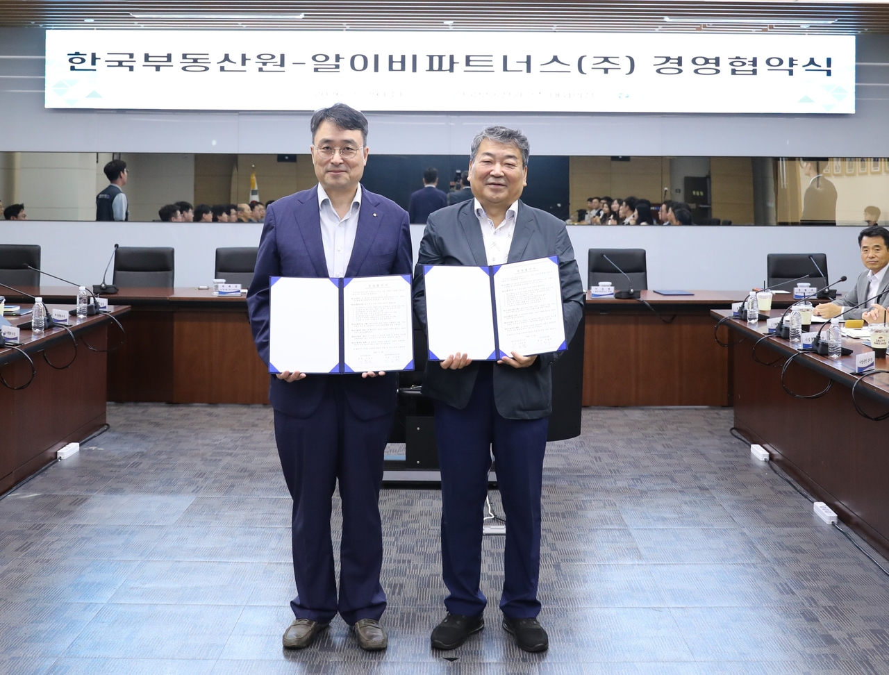 29일 이헌욱(왼쪽) 한국부동산원 원장과 이승천 알이비파트너스㈜ 사장의 ‘2026년도 모·자회사 경영협약식 개최 후 사진촬영을 하고 있다. [한국부동산원 제공]