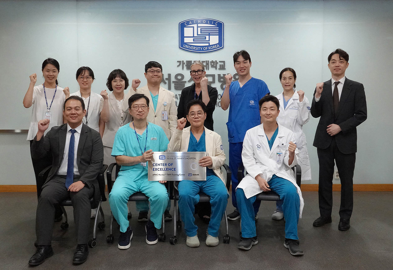 가톨릭대학교 서울성모병원 관계자들과 글로벌 헬스케어 기업 애보트사 관계자들이 지난 29일 병원에서 열린 ‘TAVI 분야 아시아·태평양 지역 우수센터(APAC COE)’ 자격 획득 기념 현판식을 마친 후 기념사진을 촬영하고 있다.[서울성모병원 제공]