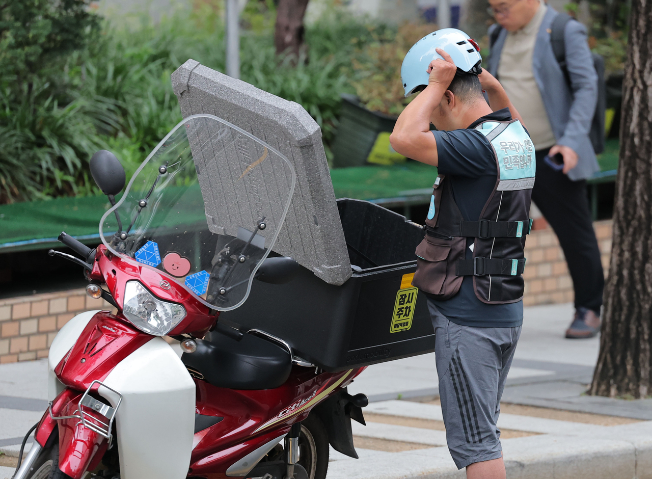 A delivery rider makes a delivery in Seoul on July 8. (Yonhap)