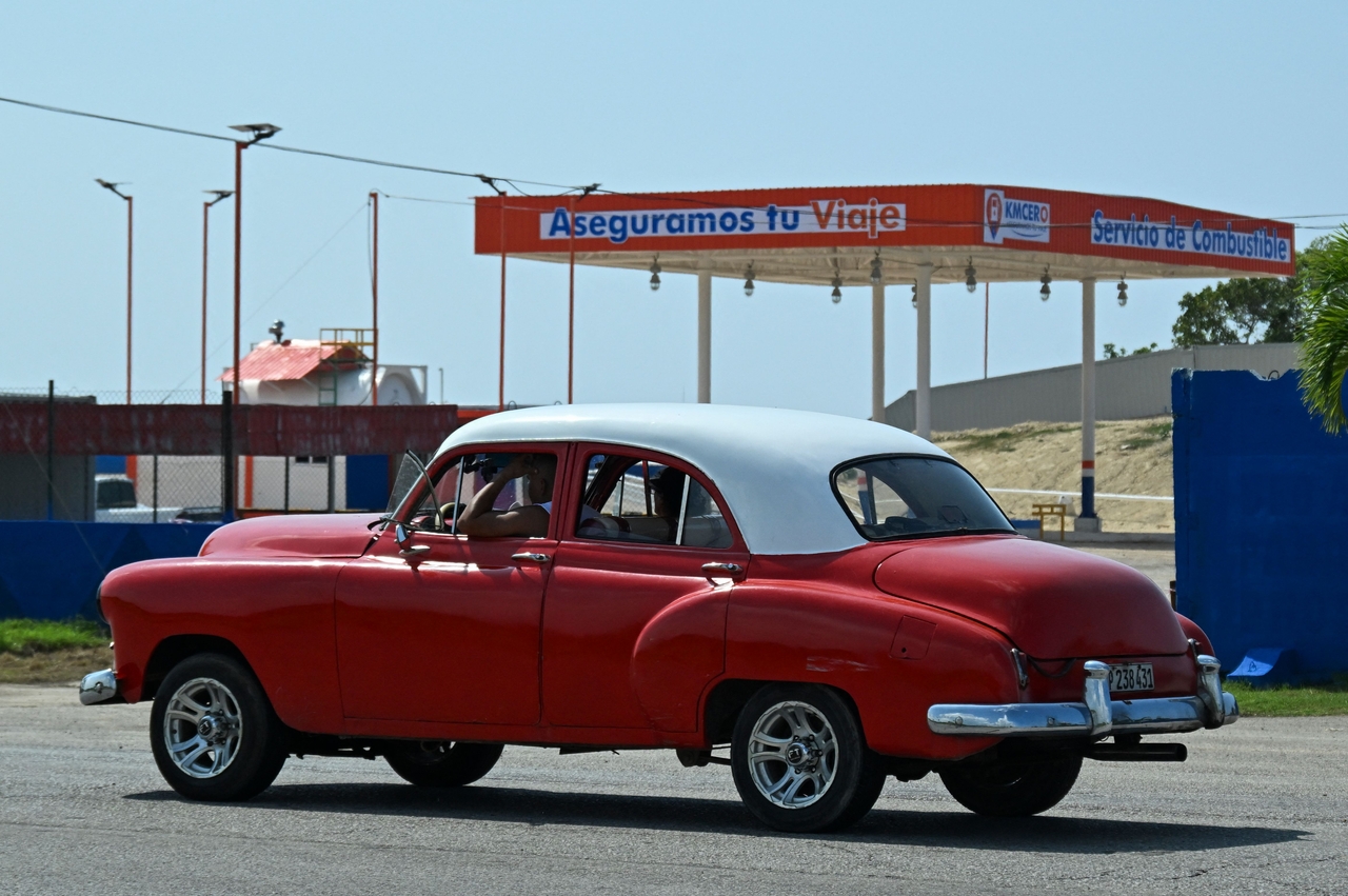An old car drives past a gas station under construction in Boca de Jaruco, Matabeque Province, Cuba, Wednesday. (AFP-Yonhap)