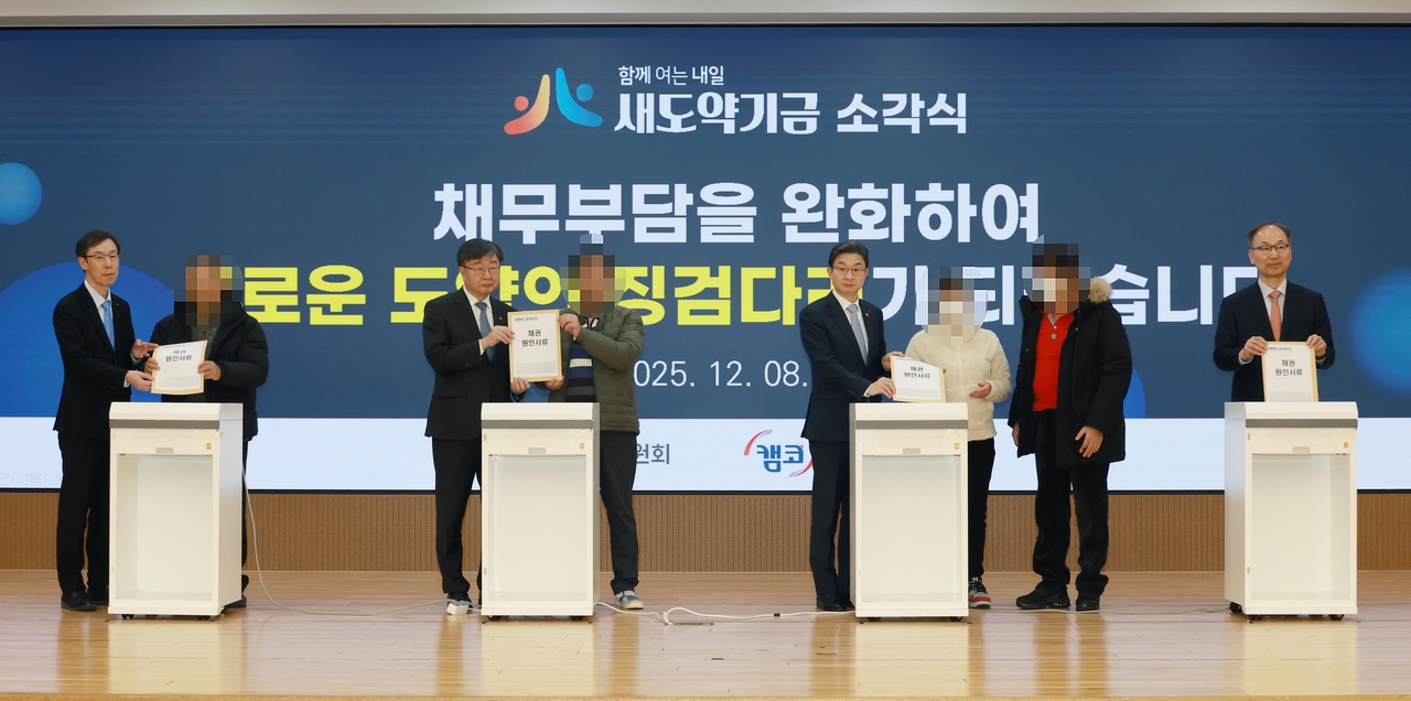 이억원(왼쪽 다섯 번째) 금융위원장이 지난해 말 부산국제금융센터에서 열린 새도약기금 소각식에서 주요 참석자들과 함께 연체채권 서류를 파쇄하는 소각 세리머니를 하고 있다. 왼쪽부터 정정훈 한국자산관리공사(캠코) 사장, 국민대표, 이재연 국민행복기금 대표, 국민대표, 이 위원장, 국민대표, 국민대표, 양혁승 새도약기금 대표. [금융위 제공]