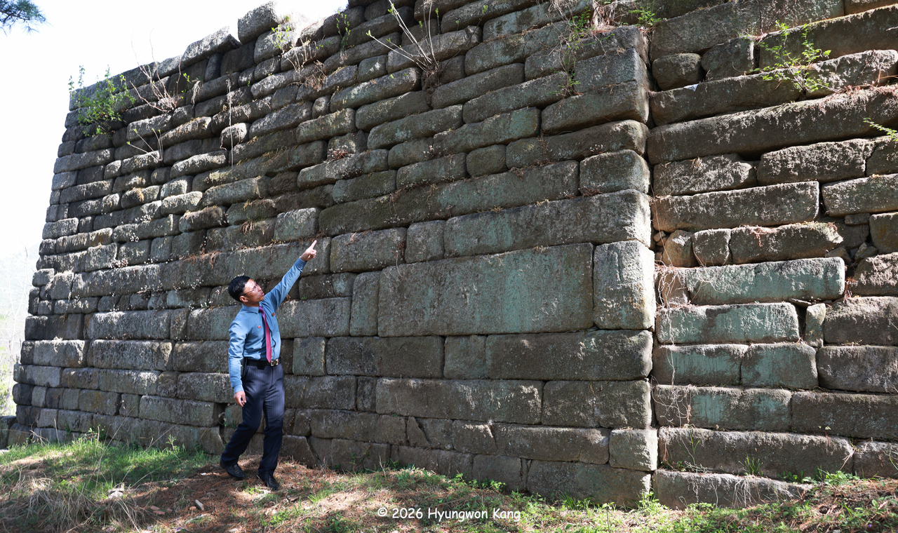 Researcher Choi Hee-guk stands dwarfed before the massive original fortress of Manwoldae, the imperial palace of the Goryeo empire in Kaesong, North Korea, as he points out details of the original fortress and explains its construction. (Hyungwon Kang)