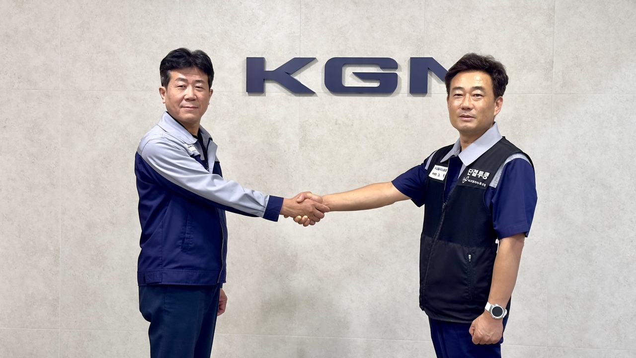 황기영(왼쪽) KG모빌리티 대표이사와 노철 노동조합 위원장이 임단협 협상 타결 후 악수를 하고 있다. [KG모빌리티 제공]