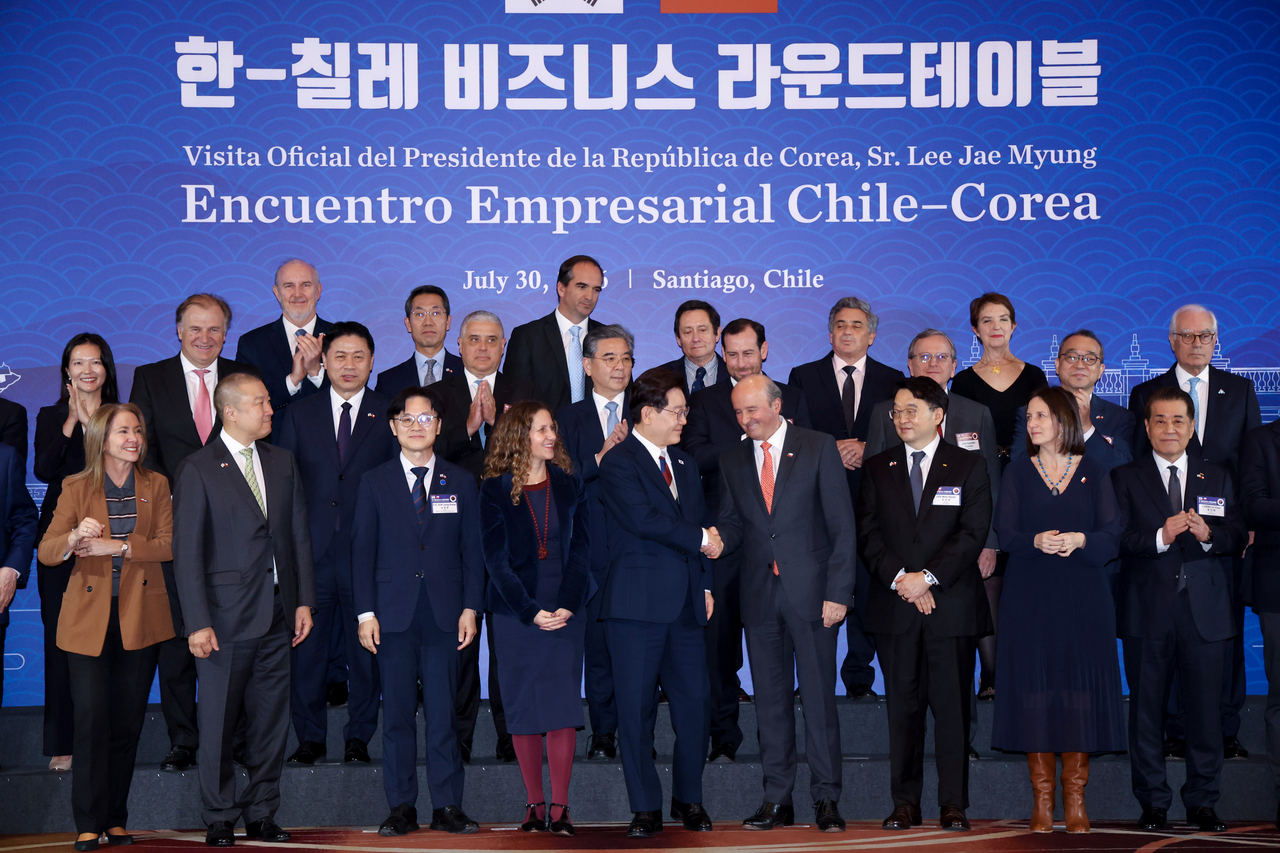 이재명(앞줄 왼쪽 다섯번째) 대통령이 30일(현지시간) 칠레 산티아고 한 호텔에서 한-칠레 비즈니스 라운드 테이블에서 기념 촬영을 마친 뒤 파트리시오 토레스 칠레 외교부 차관과 악수하고 있다. [연합]