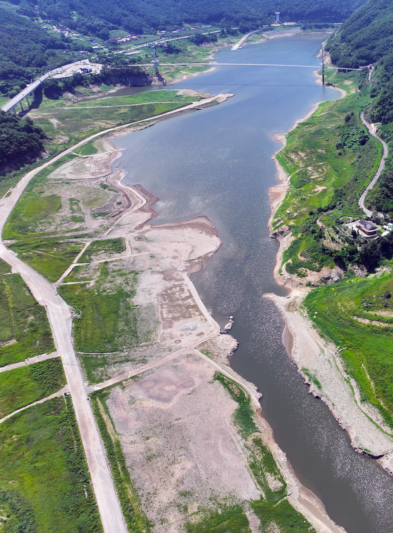 The receded shoreline of a reservoir near Bohyeonsan Dam is seen in Yeongcheon, North Gyeongsang Province, on Friday, as the region grapples with prolonged heat waves and drought. (Yonhap)