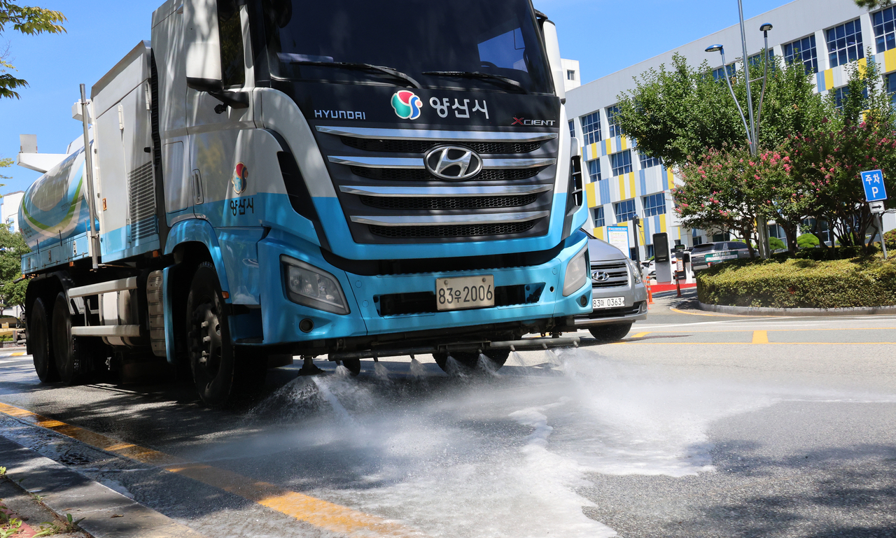 A water-spraying truck passes along a road in Nambu-dong, Yangsan, South Gyeongsang Province, on Friday, as the city recorded temperatures exceeding 40 C for the third consecutive day. (Yonhap)