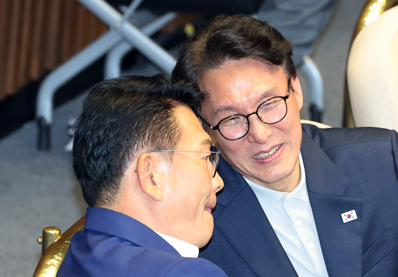 Democratic Party Reps. Kim Min-seok (right) and Song Young-gil speak during a plenary session of the National Assembly Friday. (Yonhap)