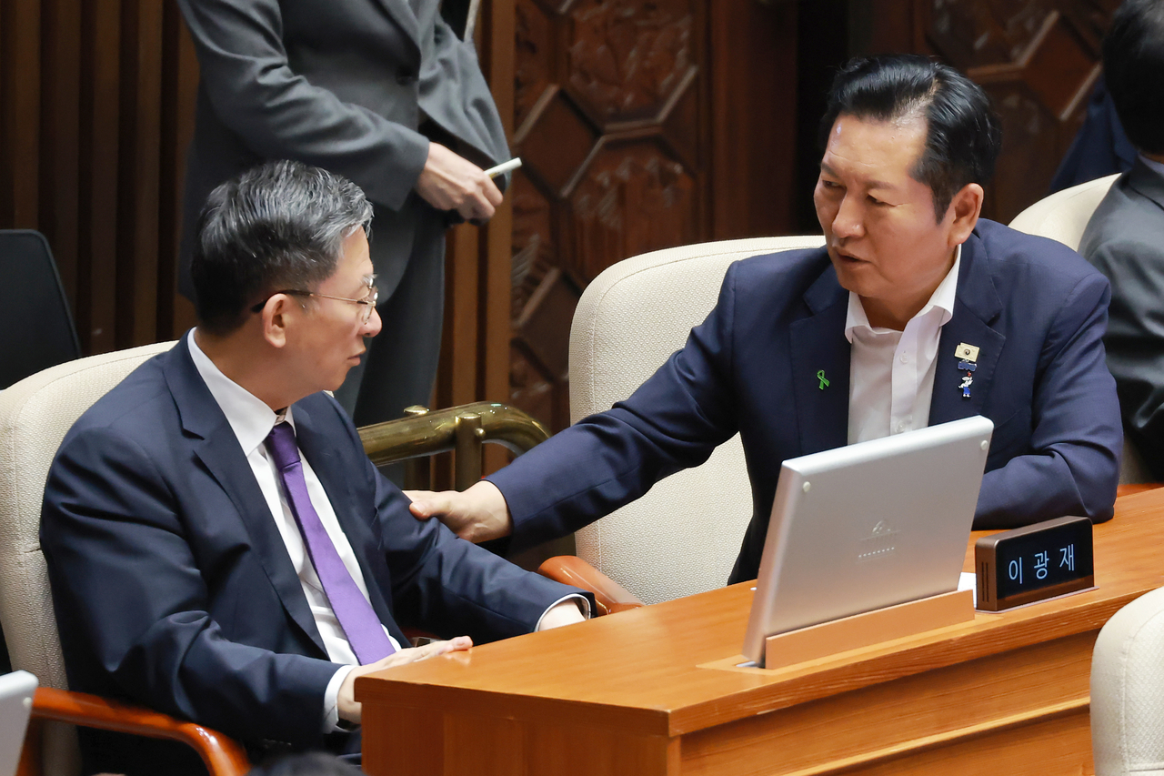 Democratic Party Rep. Jung Chung-rae (right) speaks with Justice Minister Jung Sung-ho during a plenary session of the National Assembly Friday. (Yonhap)