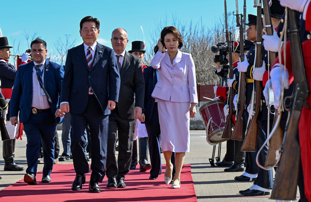 President Lee Jae Myung and first lady Kim Hea Kyung walk toward Air Force One at Ezeiza International Airport in Buenos Aires on Saturday (local time) after concluding their visit to Argentina and departing for Frankfurt, the next stop on their trip. (Yonhap)