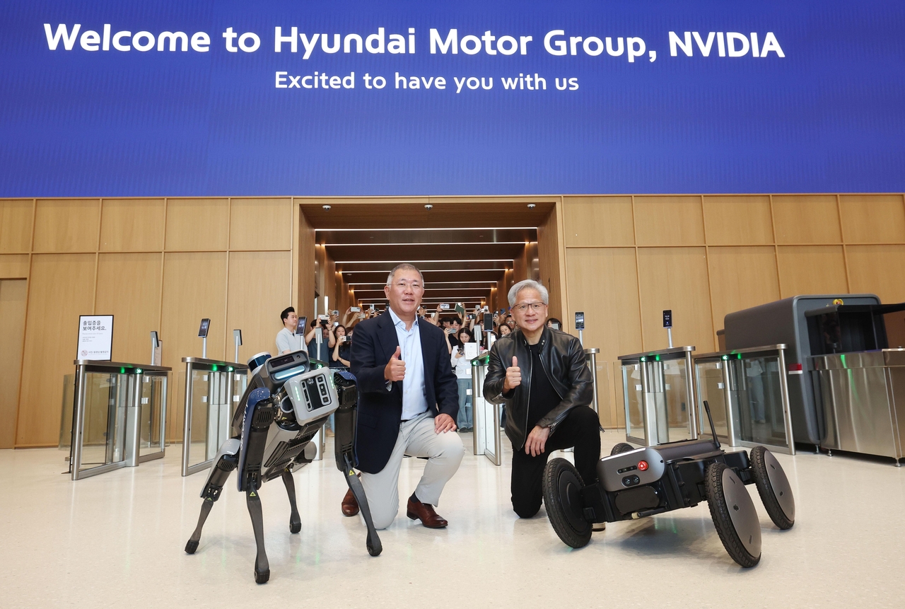 Hyundai Motor Group Executive Chair Chung Euisun (left) and Nvidia CEO Jensen Huang pose with the quadruped robot Spot and autonomous mobile robot MobED at Hyundai Motor Group’s headquarters in Yangjae, southern Seoul, on June 8. (Newsis)