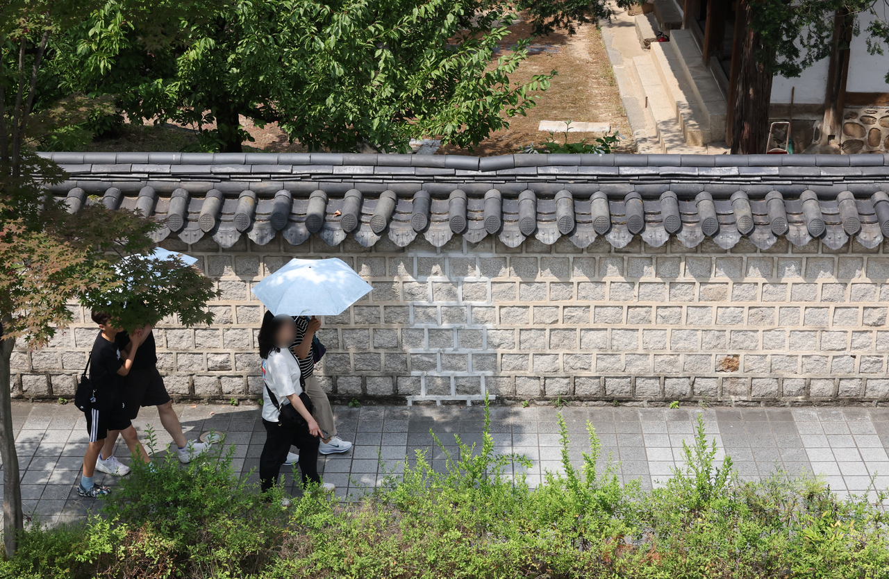 Pedestrians carrying umbrellas are seen in the southwestern city of Jeonju on Saturday. (Yonhap)