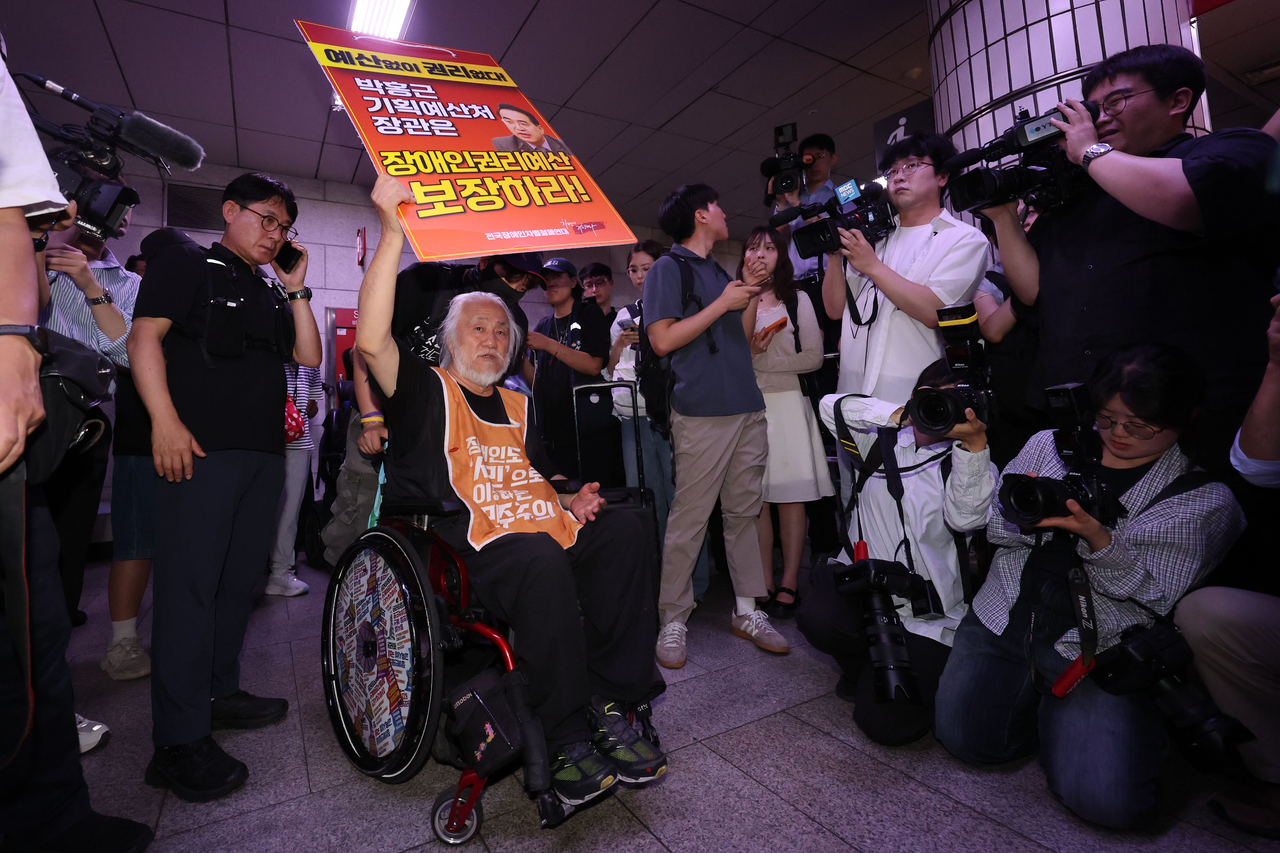 SADD leader Park Kyoung-seok holds a placard during the group’s 69th rush-hour subway protest at City Hall Station in central Seoul on July 2. (Newsis)