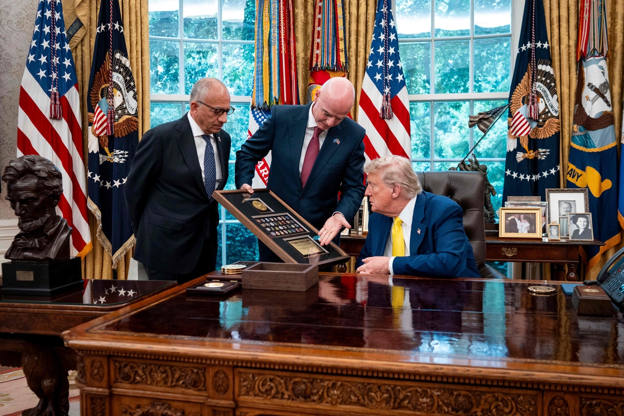Then former president of the US Soccer Federation Carlos Cordeiro (left) looks on as FIFA President Gianni Infantino (center) presents a gift to US President Donald Trump, at the Oval Office of the White House in Washington, June 18, 2025.     (AFP-Yonhap)