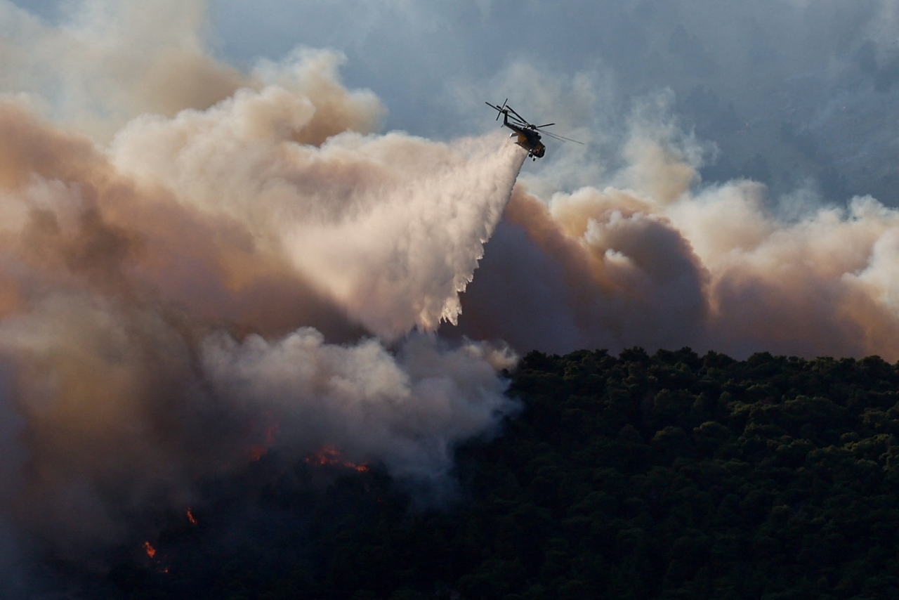 A firefighting helicopter drops water during a wildfire in Krio Pigadi, Greece, Saturday. (Reuters-Yonhap)