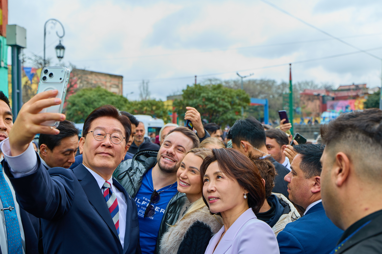 President Lee Jae Myung and first lady Kim Hye Kyung take a commemorative photo with citizens during a visit to the La Boca district of Buenos Aires on Aug. 1 (local time), after concluding their visit to Argentina. (Yonhap)