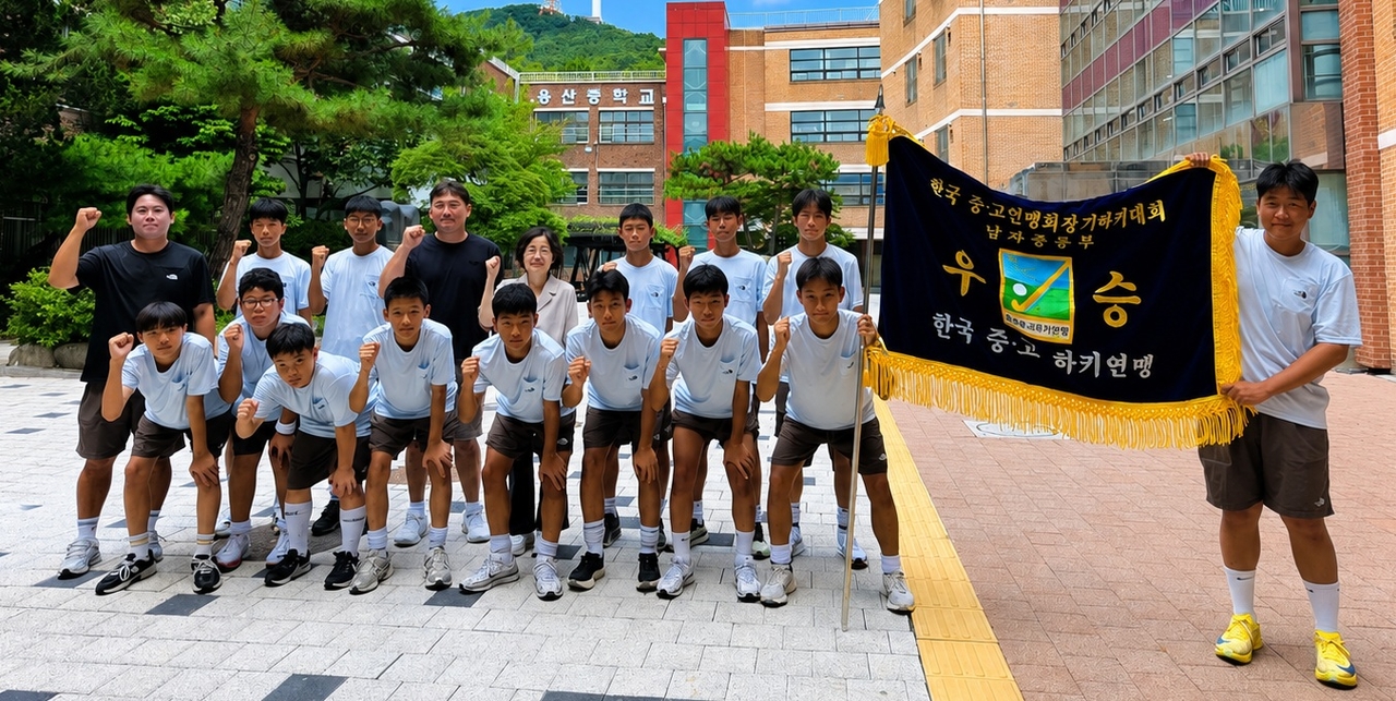 용산중학교 하키부 선수단과 곽호원 교장, 지도진이 27년 만의 전국대회 우승기와 함께 기념촬영을 하고 있다. 양정원 기자