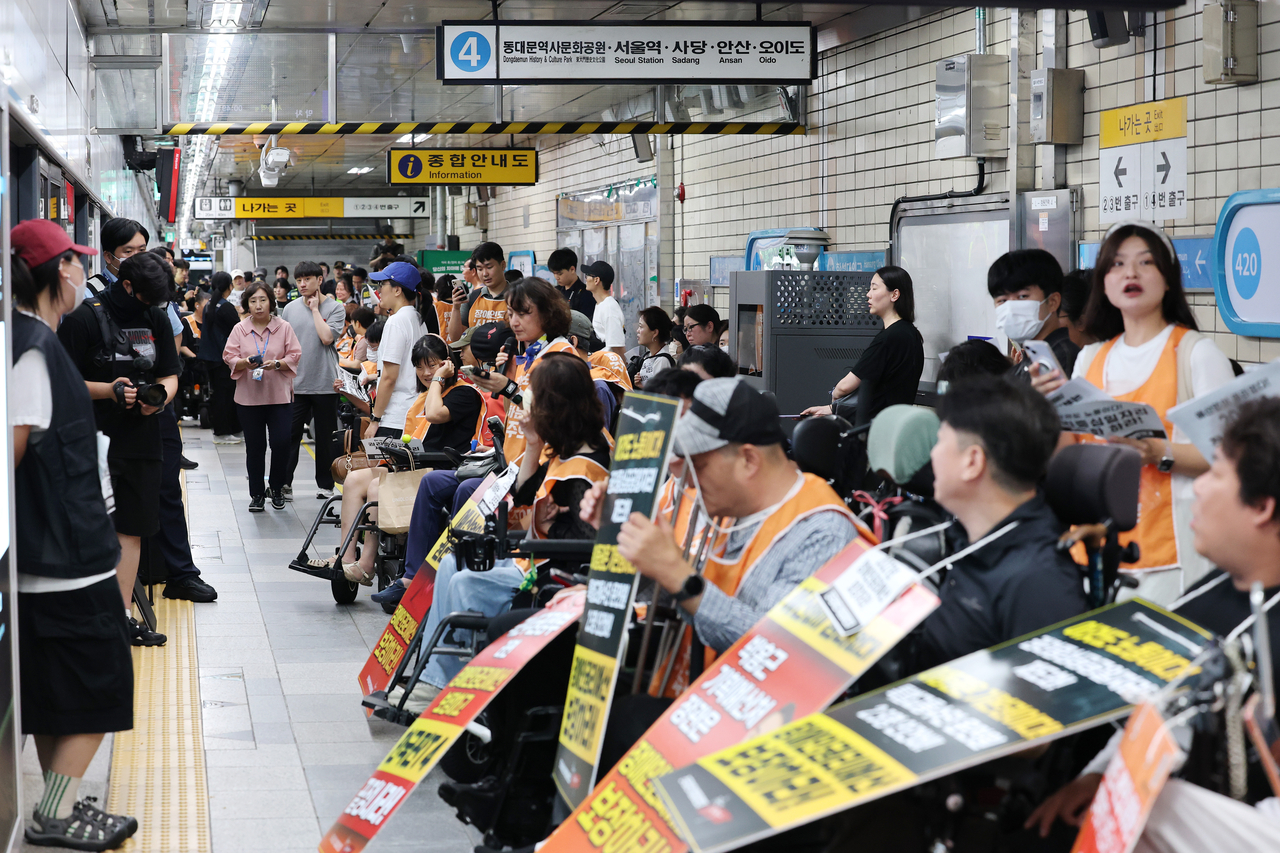 Activists from the Solidarity Against Disability Discrimination stage a protest to demand the government allocate a sufficient budget for the rights of disabled people at Hyehwa Station in Seoul on Monday. (Yonhap)